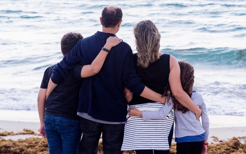 Family standing watching the beach